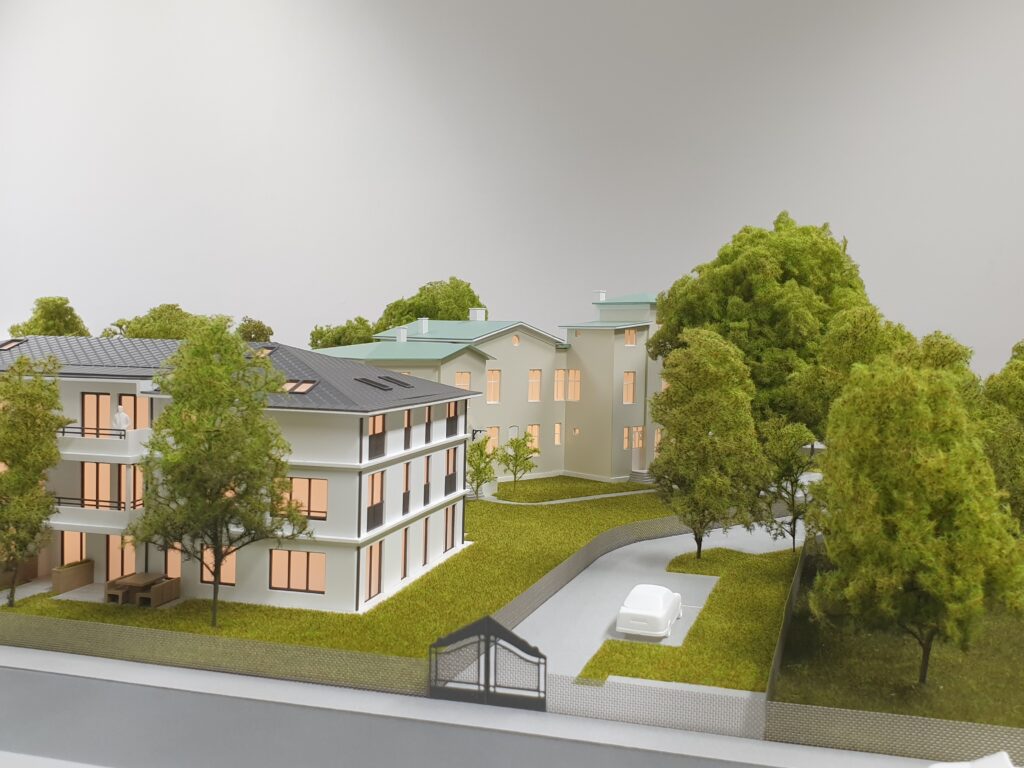 Architekturmodell 1:100 – Wohnhäuser mit Grünanlagen, Bäumen und realistisch gestalteter Umgebung.