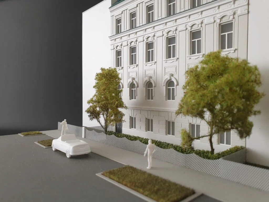 Detailansicht eines Architekturmodells im Maßstab 1:200 – Fassade mit Bäumen, Auto und Figuren zur realistischen Wirkung.