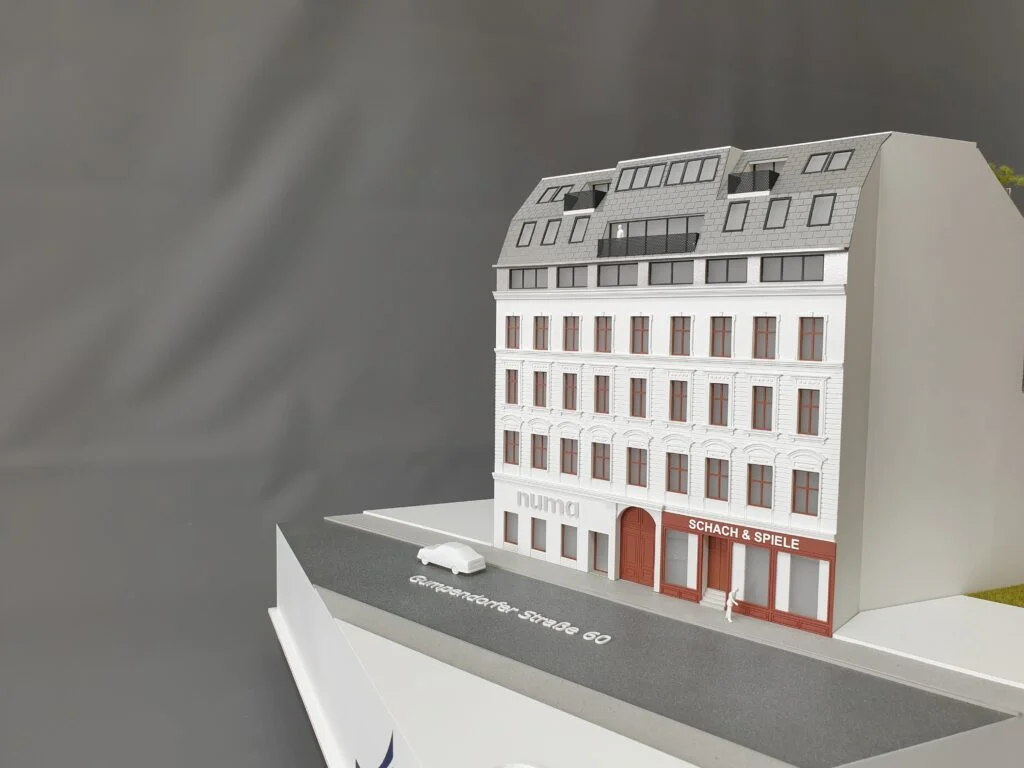 Architekturmodell – Altbau mit Sanierung und Dachausbau, farbige Fassade und straßenseitiger Eingang.