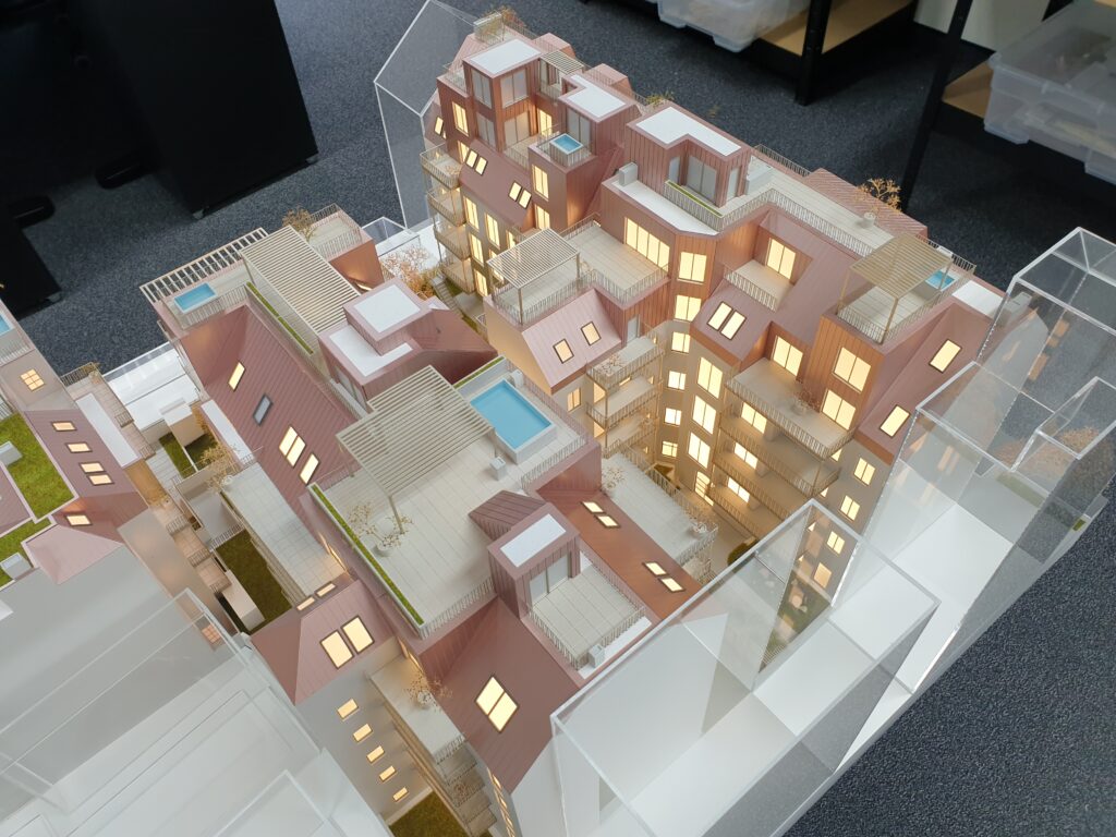 Architekturmodell Wohnanlage mit Dachterrassen, Pool und Beleuchtung – detailreiches Verkaufsmodell für Immobilienpräsentationen.