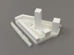 Weißes 3D-Druck Modell mit zwei Hochhäusern, Baukörpern und Platzgestaltung, präsentiert auf grauem Hintergrund.