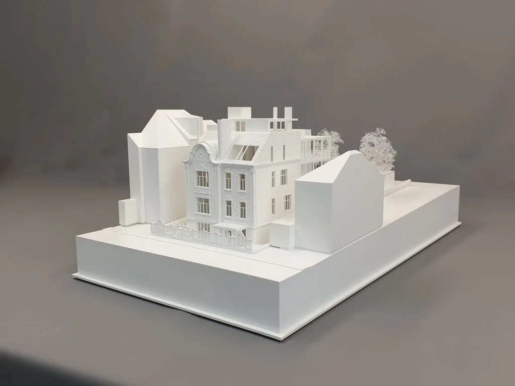 rchitekturmodell im Maßstab 1:200: Wettbewerbsmodell einer Villa mit historischer Fassade und modernem Dachausbau. Material: weißes Polystyrol, ideal für Wettbewerbe und städtebauliche Präsentationen.