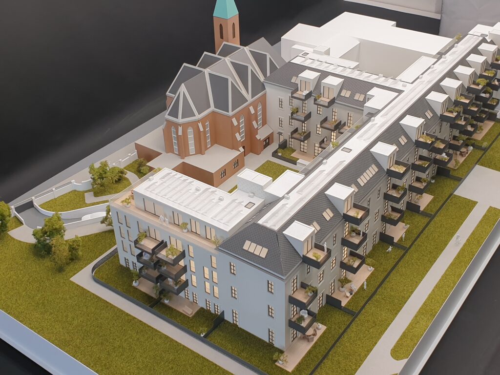 Architekturmodell Wohnquartier mit Balkonen, Grünflächen und Kirchturm – Verkaufsmodell für Immobilienpräsentationen.