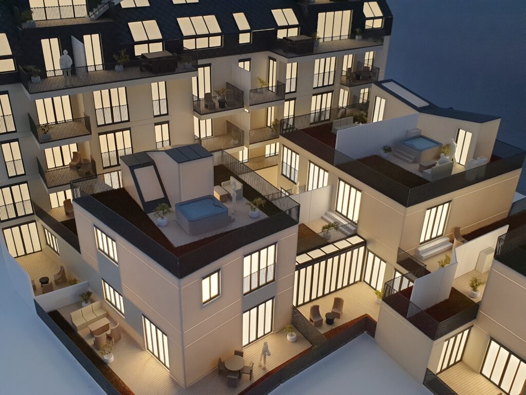 Architekturmodell 1:100 – Wohnanlage mit Beleuchtung, Balkonen und detaillierten Fassaden.