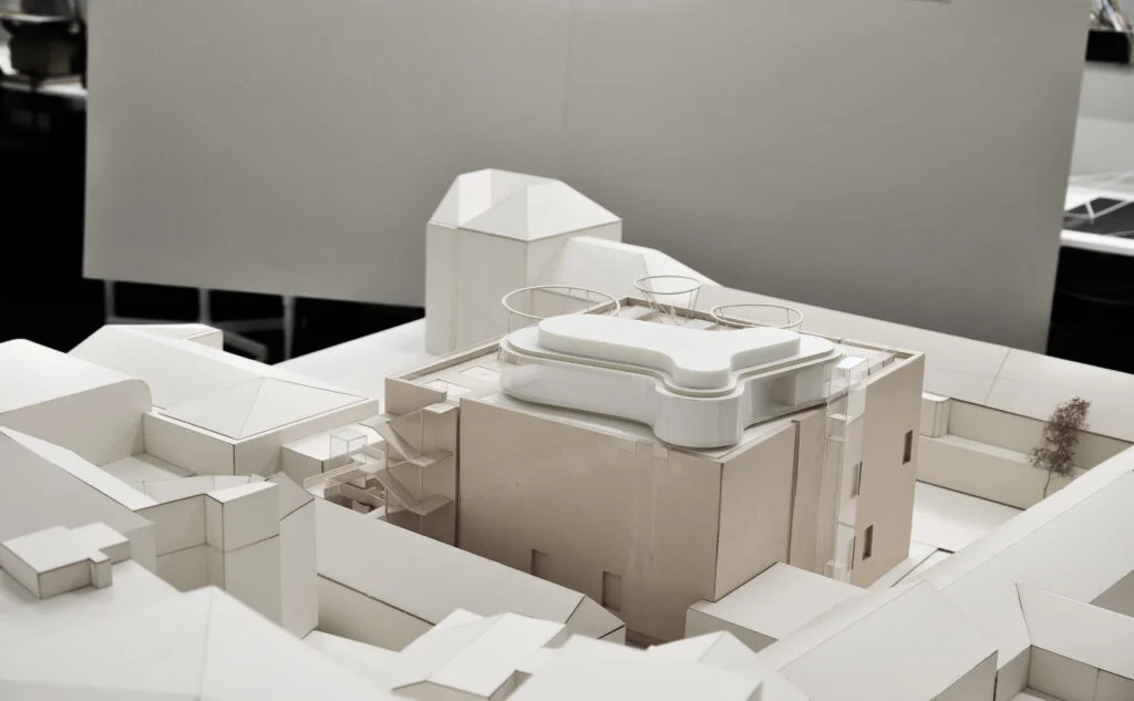 Architekturmodell – moderner Gebäudekomplex mit organischen Dachformen, abstrahiert in Weiß.