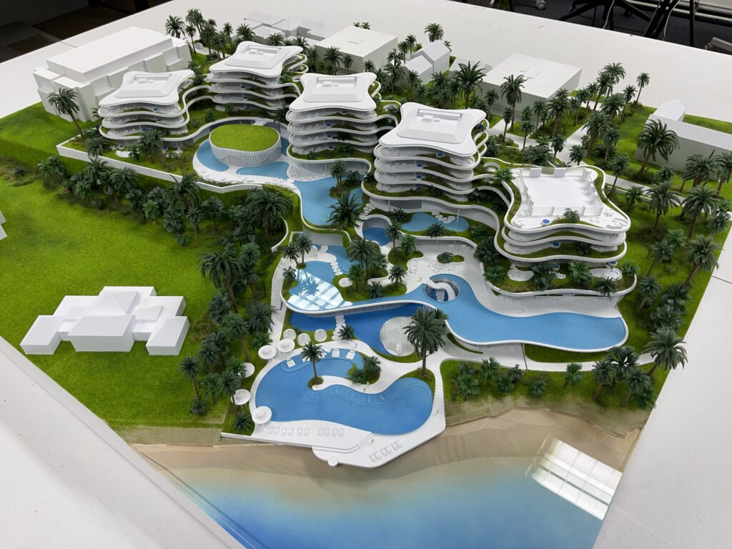Architekturmodell 1:200 – Resortanlage mit Pools, Palmen, Strandzugang und modernen Gebäuden, detailreich gefertigt.