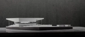 Weißes 3D-Druck Modell eines modernen Pavillons mit flacher Dachstruktur und transparenter Gestaltung, präsentiert auf schwarzer Fläche.