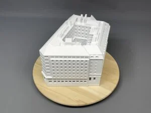 Weißes 3D-Druck Modell eines historischen Gebäudes mit Innenhof, detailreicher Fassadenstruktur, auf rundem Holzsockel.