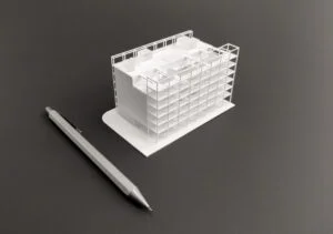 Miniatur-Wettbewerbsmodell mit Rasterstruktur neben einem Stift als Grössenreferenz – präzise und detailreich gefertigt.