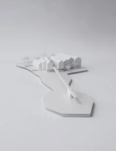 Weißes Wettbewerbsmodell mit länglichen Gebäuden mit Satteldach und Fußgängerbrücke auf abstrahierter Geländeplattform