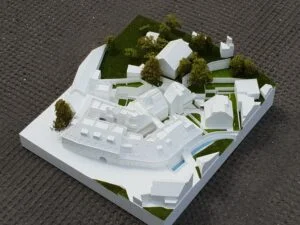 Weißmodell eines Wohnensembles mit begrünten Innenhöfen, Wegeführung und angrenzenden Gebäuden im Maßstab 1:500.