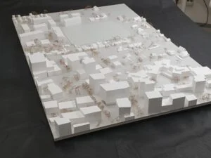 Städtebauliches Weißmodell mit klaren Baukörpern, Straßenstruktur und farblich akzentuierten Modellbäumen im Quartier.