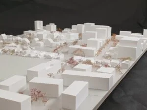 Städtebauliches Weißmodell mit vielfältigen Baukörpern und farblich akzentuierten Modellbäumen im Quartier.