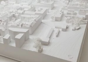 Städtebauliches Weißmodell mit klaren Baukörpern, Verkehrsachsen und feinen Baumstrukturen im umliegenden Quartier.