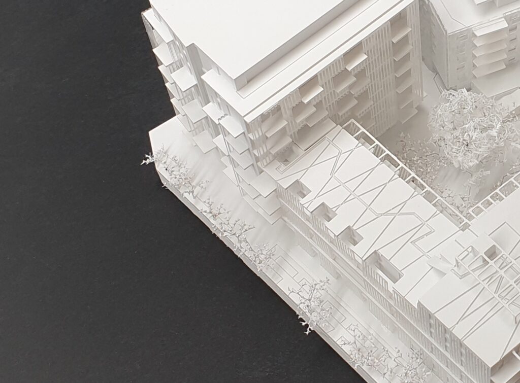 Detailaufnahme eines Wettbewerbsmodells mit Fassadenelementen und Dachstrukturen im Innenhofbereich.