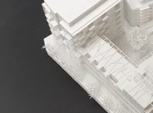 Detailaufnahme eines Wettbewerbsmodells mit Fassadenelementen und Dachstrukturen im Innenhofbereich.