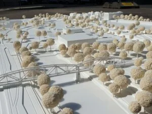 Weißes Umgebungsmodell mit Brückenkonstruktion, Verkehrsstrukturen und dichter Baumlandschaft.