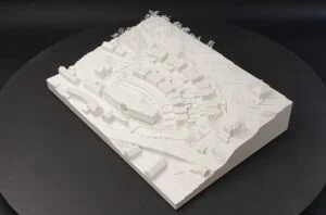 Weißes Geländemodell in Hanglage mit terrassierter Bebauungsstruktur und feinen Baumelementen.