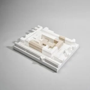 Ausstellungsmodell im Maßstab 1:500 mit weißen Umgebungsvolumen und sandfarbenen Baukörpern auf rechteckiger Basis.