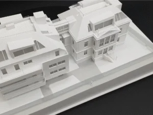 Weißes Architekturmodell einer historischen Stadtvilla mit modernem Erweiterungsbau und Innenhof im Maßstab auf schwarzem Hintergrund.