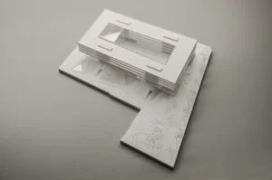 Weißmodell eines Flachbaus mit umlaufenden horizontalen Bändern und Landschaftsfläche im Präsentationskontext.