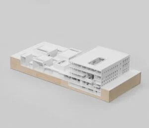 Weißes Architektur-Schnittmodell auf Holzsockel mit offenen Geschossen und Innenstruktur als Präsentationsmodell.