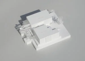 Weißmodell zweier Baukörper mit Innenhof und reduzierter Außenraumgestaltung im Entwurfskontext.