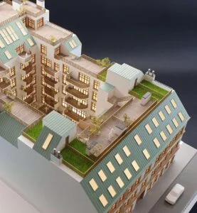 Architekturmodell mit Dachausbau, begrünten Terrassen und beleuchteten Innenräumen im hochwertigen Detailgrad.