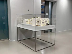 Architekturmodell eines Wohngebäudes in Glasvitrine im Showroom, Präsentation auf Metallgestell
