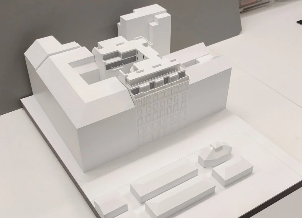 Weißmodell eines innerstädtischen Gebäudekomplexes mit modernem Dachausbau und klarer Volumenstudie.