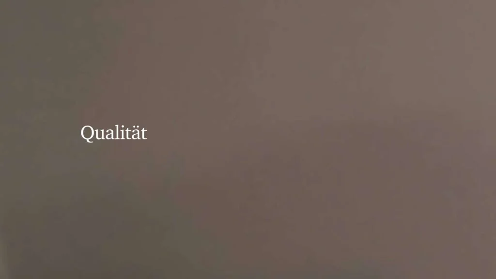 Typografische Darstellung des Wortes „Qualität“ als visuelles Statement in der Präsentation von Architekturmodellen