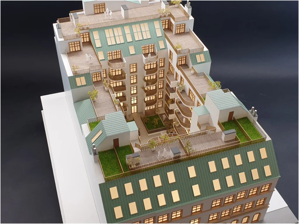 Architekturmodell eines Altbau-Wohngebäudes mit Innenhof, Dachterrassen und komplexer Dachlandschaft.