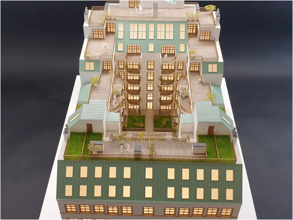 Architekturmodell eines Altbau-Wohngebäudes mit symmetrischem Innenhof, Balkonen und Dachterrassen.