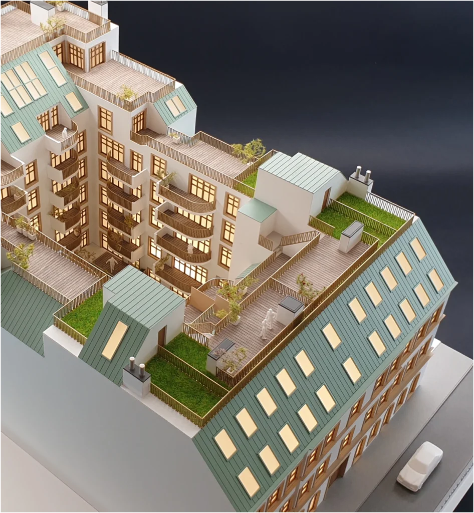 Detailansicht eines Altbau-Wohnmodells mit Dachterrassen, Balkonen und begrünten Dachflächen.