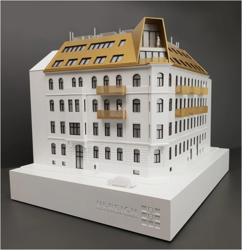 Architekturmodell eines Altbau-Wohngebäudes in Eckansicht mit modernem Dachausbau und Balkonen.