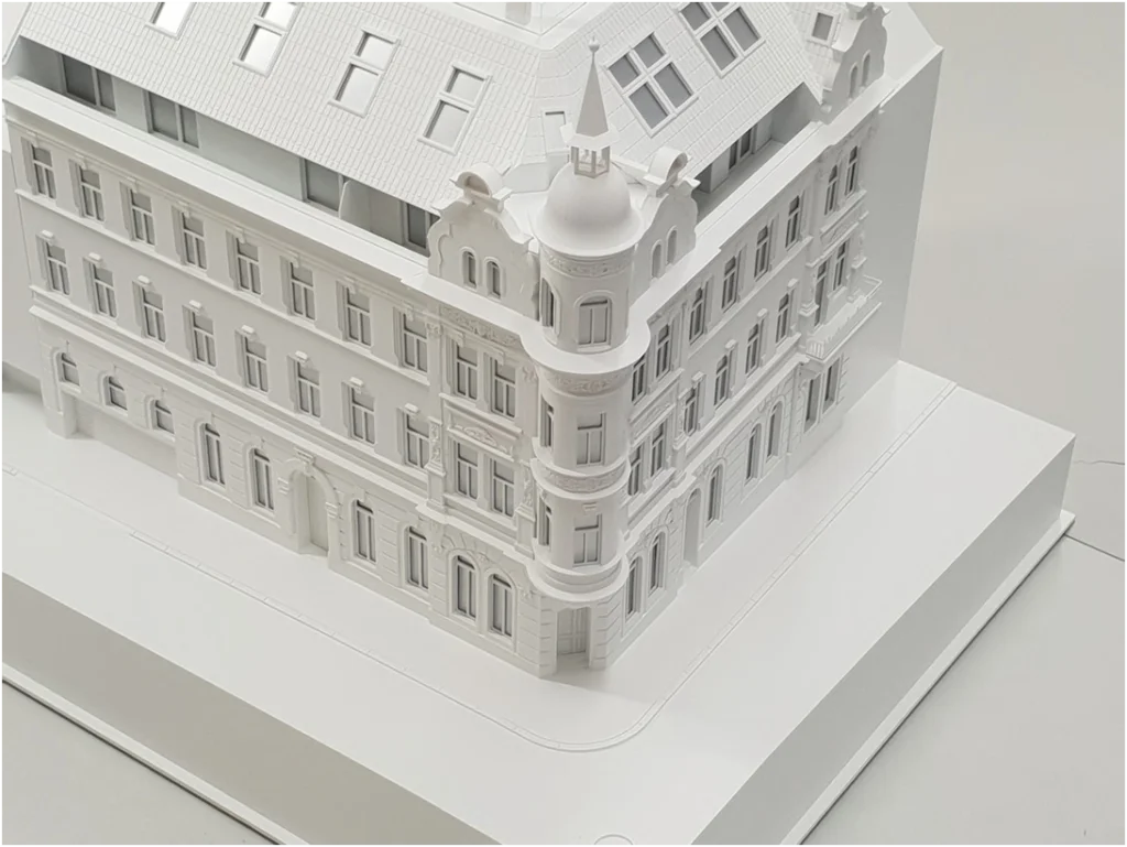 Detailansicht eines Altbau-Weißmodells mit Eckturm, Stuckfassade und historischer Fensterstruktur