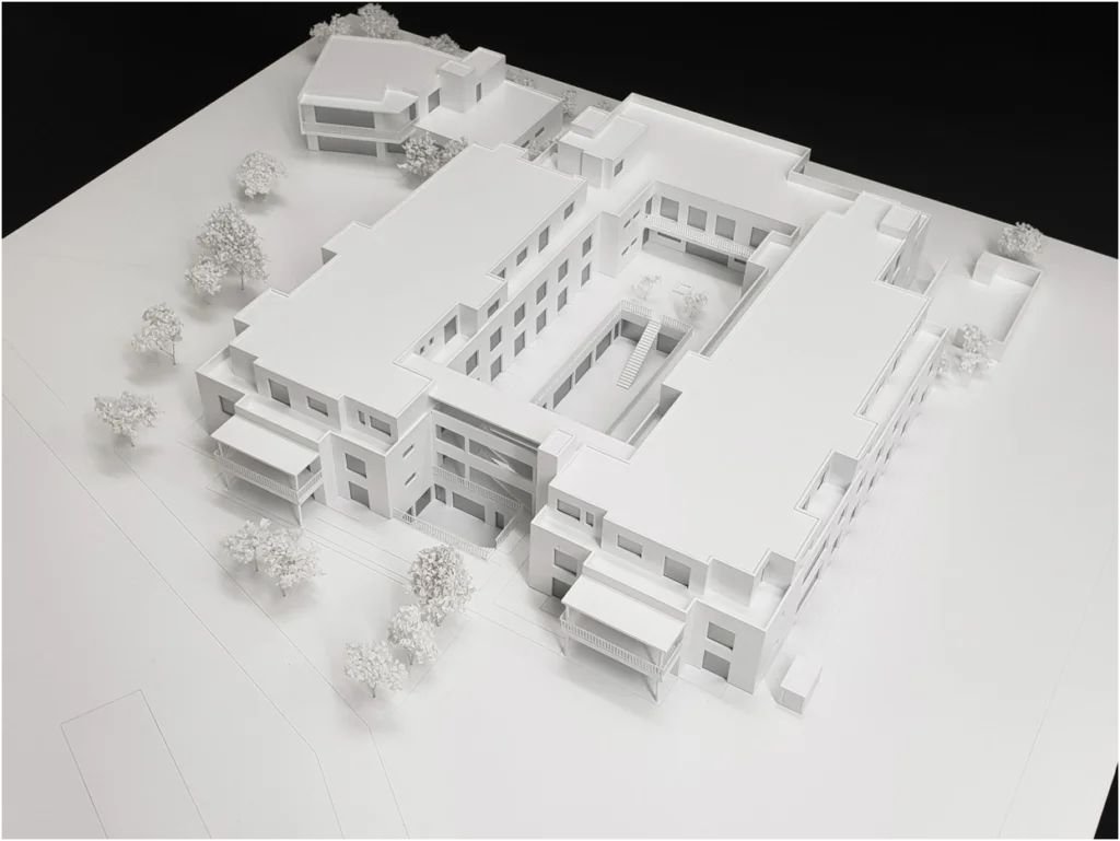 Weißmodell eines modernen Immobilienkomplexes mit Innenhof und klarer Gebäudestruktur