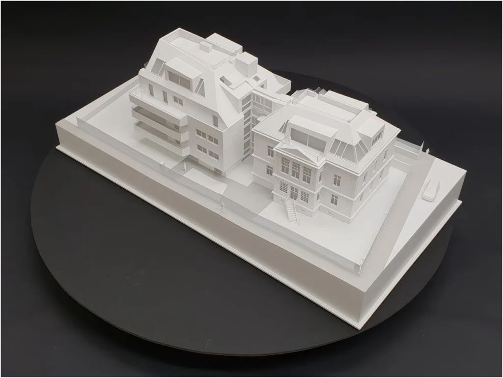 Weißmodell eines Immobilienprojekts mit Altbau und zeitgenössischem Neubau