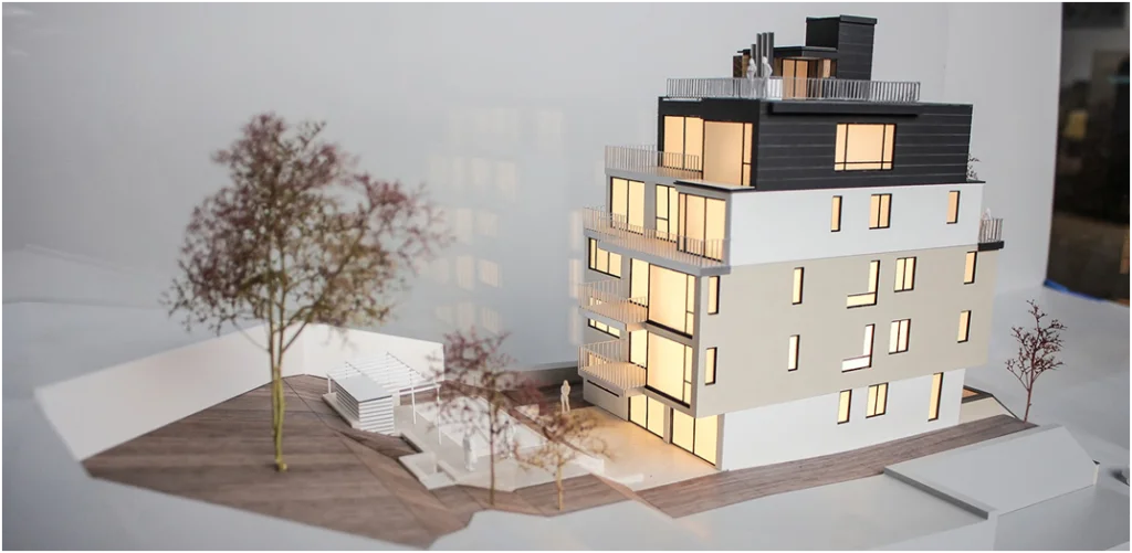 

Architekturmodell eines Wohngebäudes mit Balkonen, Dachterrasse und integrierter Beleuchtung