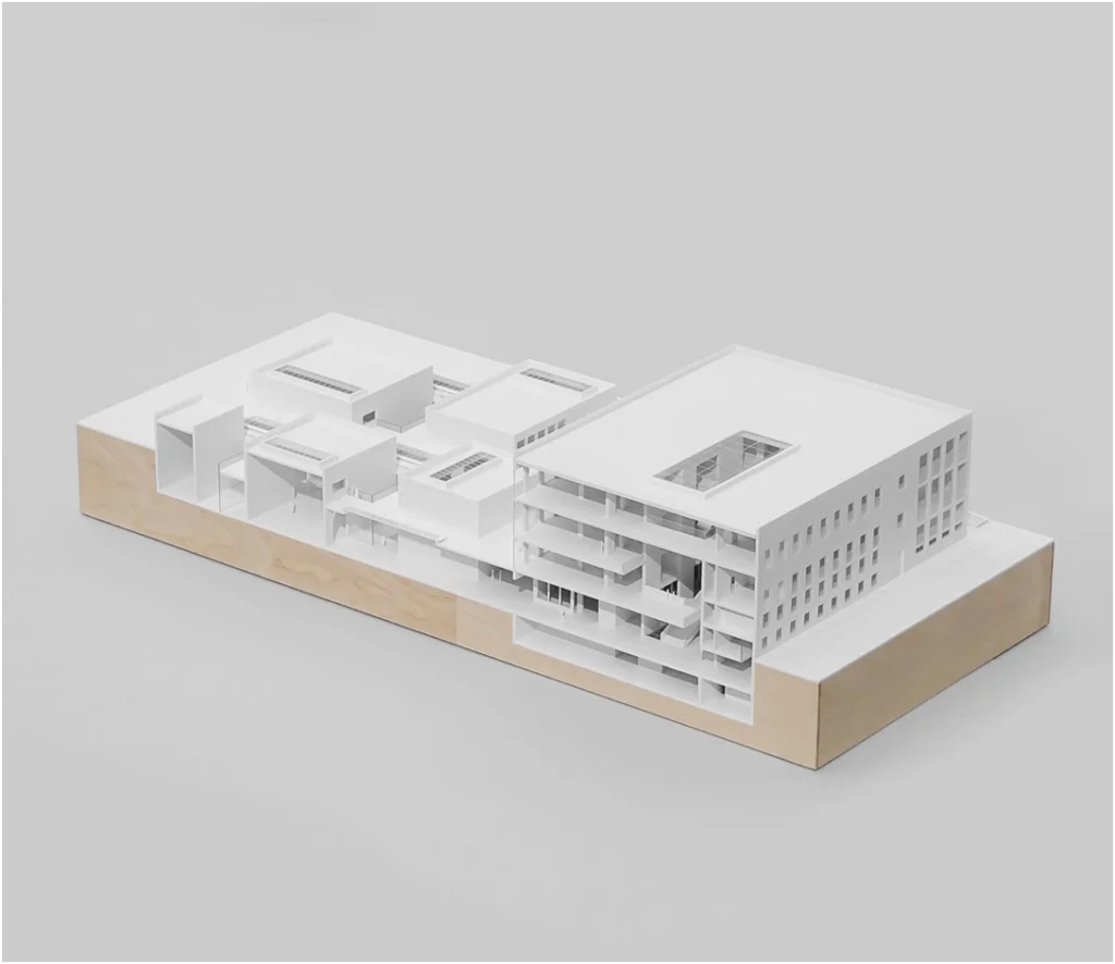 Weißmodell eines Gebäudekomplexes mit Schnittdarstellung und sichtbarer innerer Struktur