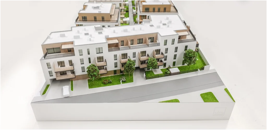 Hochdetailliertes Immobilienmodell einer modernen Wohnanlage im Maßstab 1:100 mit präziser Darstellung von Balkonen, Loggien und Grünanlagen
