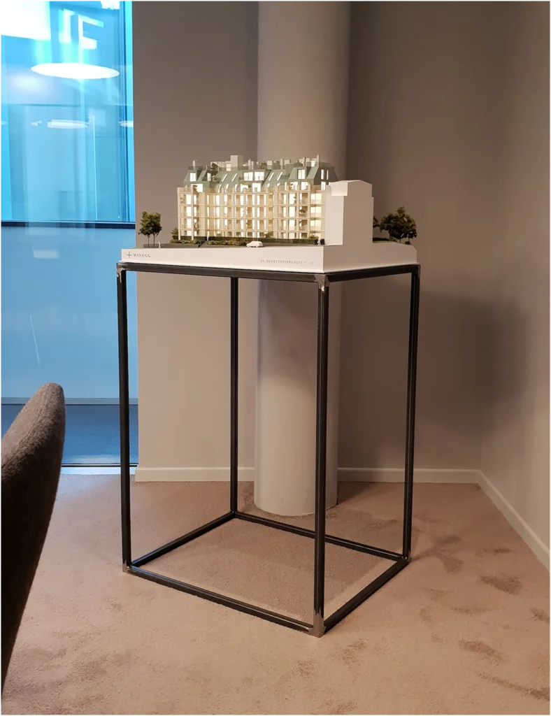 Beleuchtetes Immobilienmodell im Maßstab 1:100 mit Fokus auf luxuriöse Dachterrassen und detaillierte Fassadengestaltung