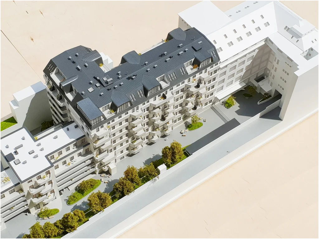 Modernes Architekturmodell einer Wohnanlage im Maßstab 1:100 mit markanten Wellenbalkonen und detaillierter Straßengestaltung