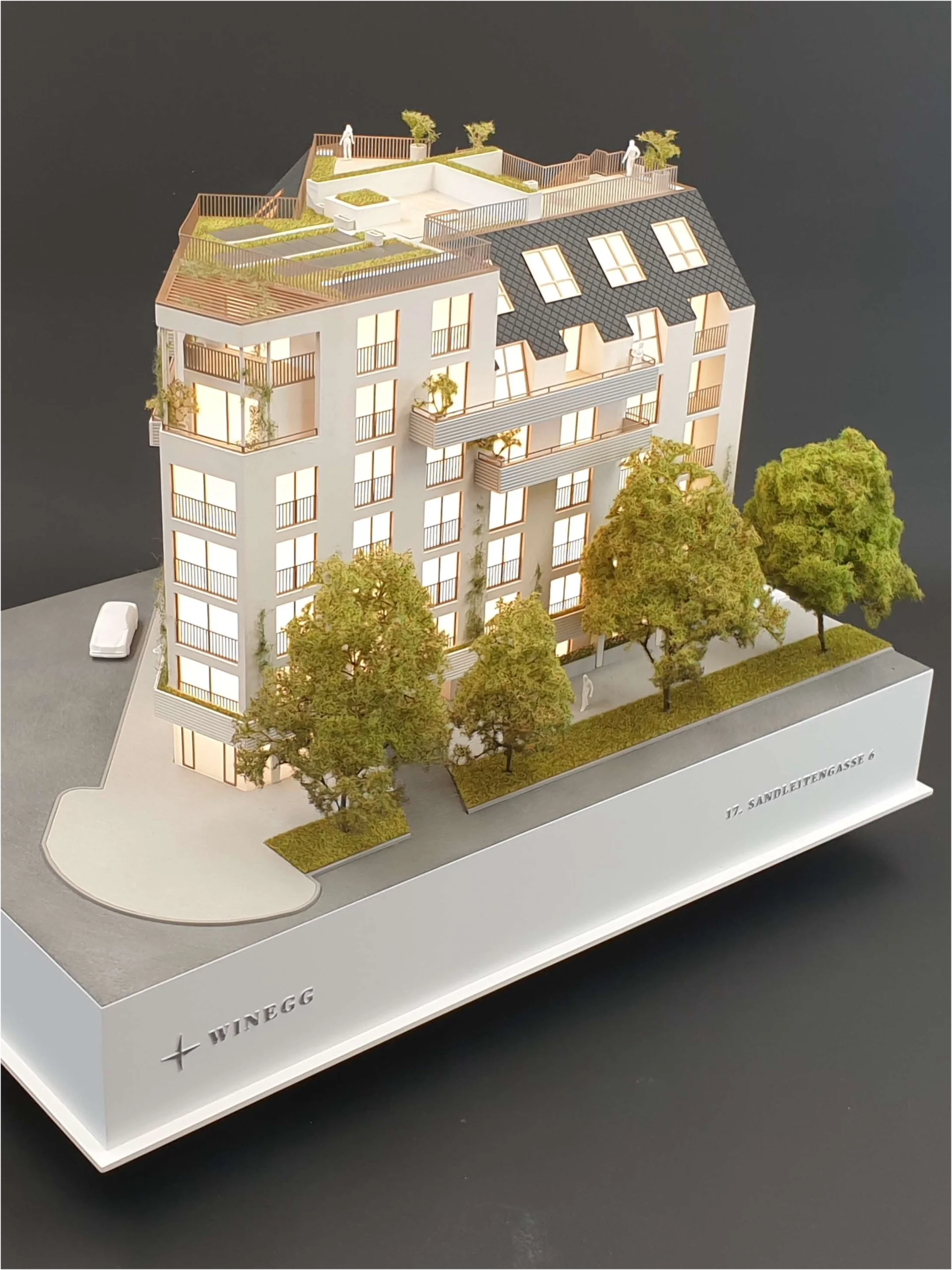 Architekturmodell eines Wohngebäudes mit Projektbeschriftung „WINEGG“ und Straßenbeschriftung „17. Sandreitengasse“, detaillierte Fassaden und begrünte Dachterrassen