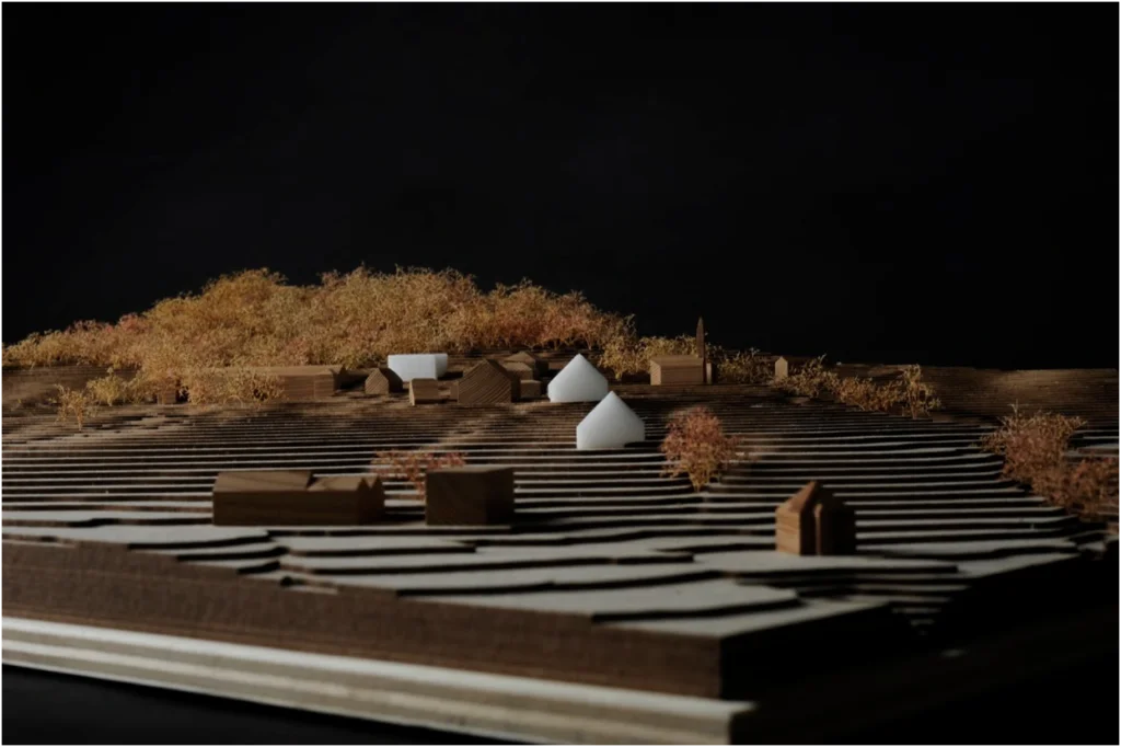 Landschaftliches Architekturmodell aus Holz mit terrassierter Topografie, abstrahierter Bebauung und Vegetationsdarstellung