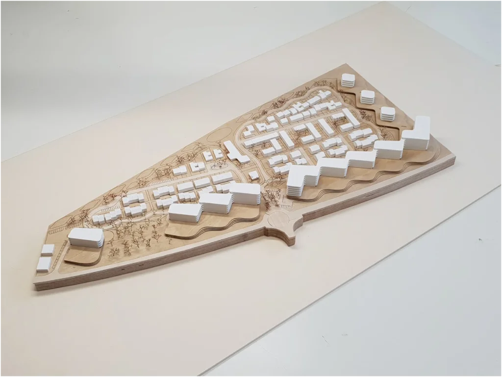 Draufsicht auf ein Architekturmodell aus Holz mit blockartiger Bebauung, klarer Hofstruktur und integrierter Vegetationsanordnung