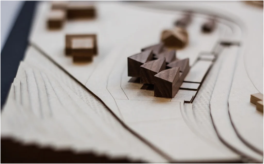 Detailansicht eines städtebaulichen Architekturmodells aus Holz mit abstrahierten Baukörpern auf gelaserter, topografischer Grundlage