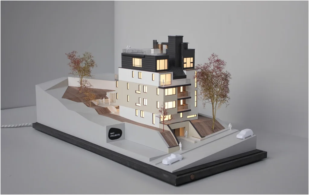 Architekturmodell eines modernen Wohngebäudes – beleuchtetes Präsentationsmodell mit Topografie und Außenraumgestaltung
