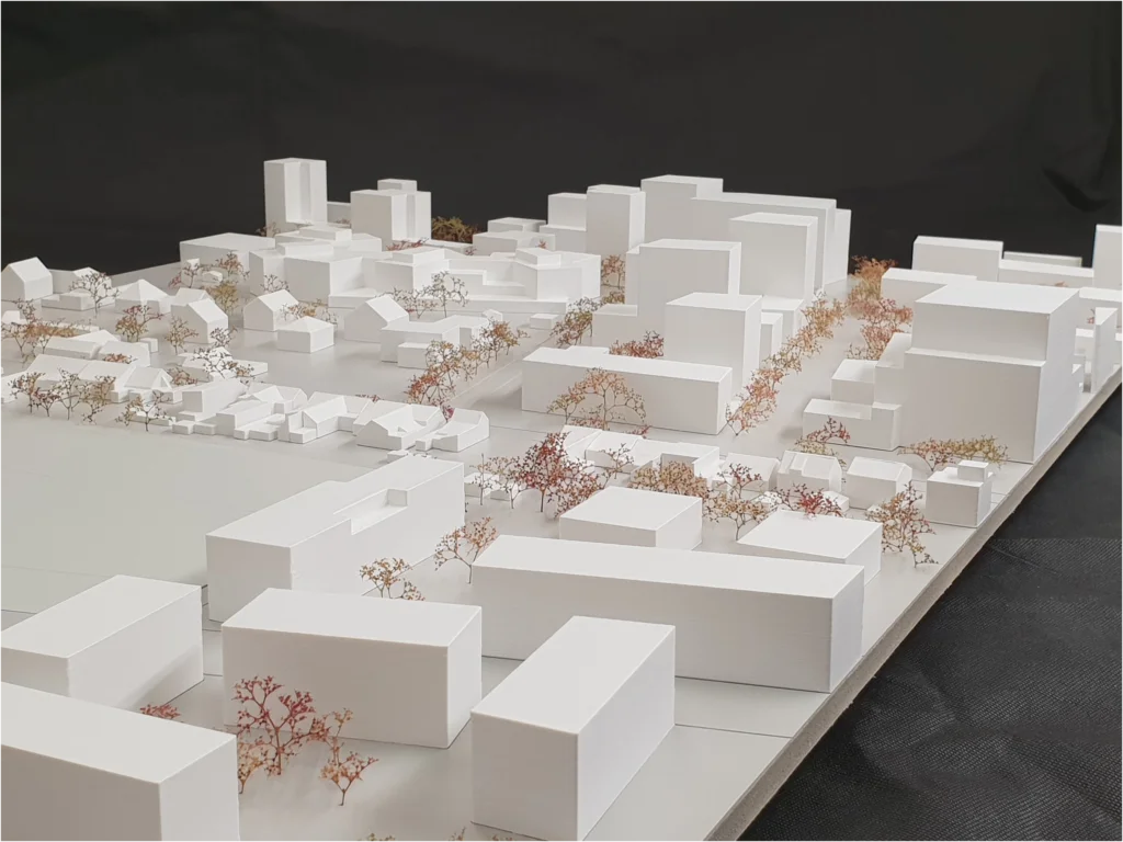 Umgebungsmodell aus weißem Karton mit Stadtstruktur, Blockbebauung und farblich akzentuierter Baumbepflanzung