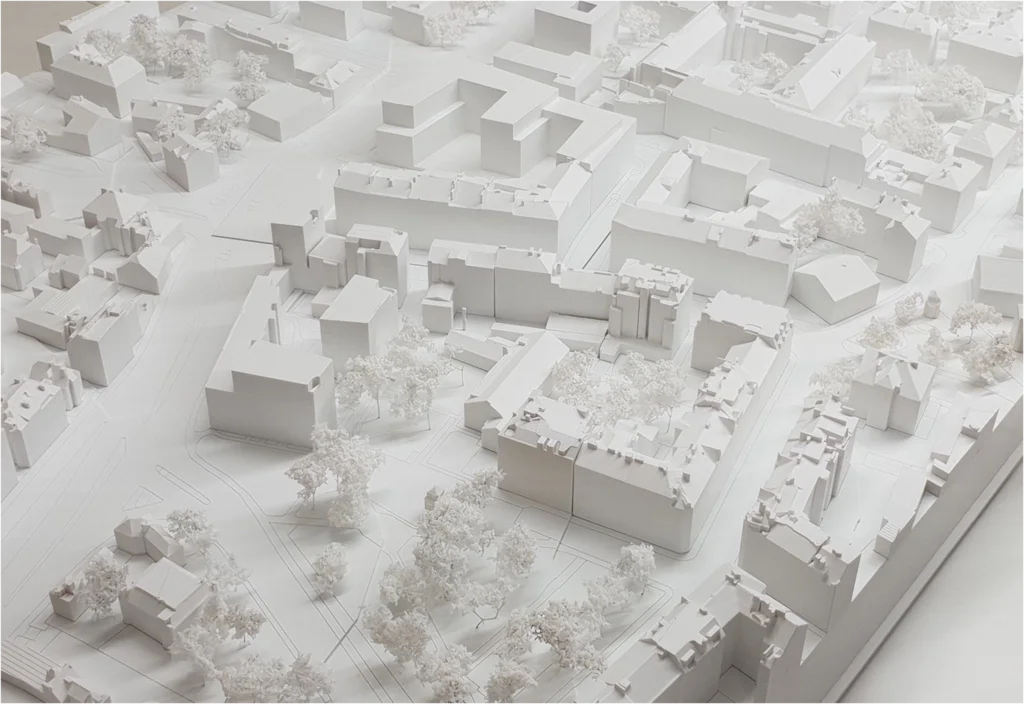 Weißes Umgebungsmodell eines Stadtgebiets mit Blockbebauung, Straßenverläufen und Baumbestand – städtebauliches Architekturmodell